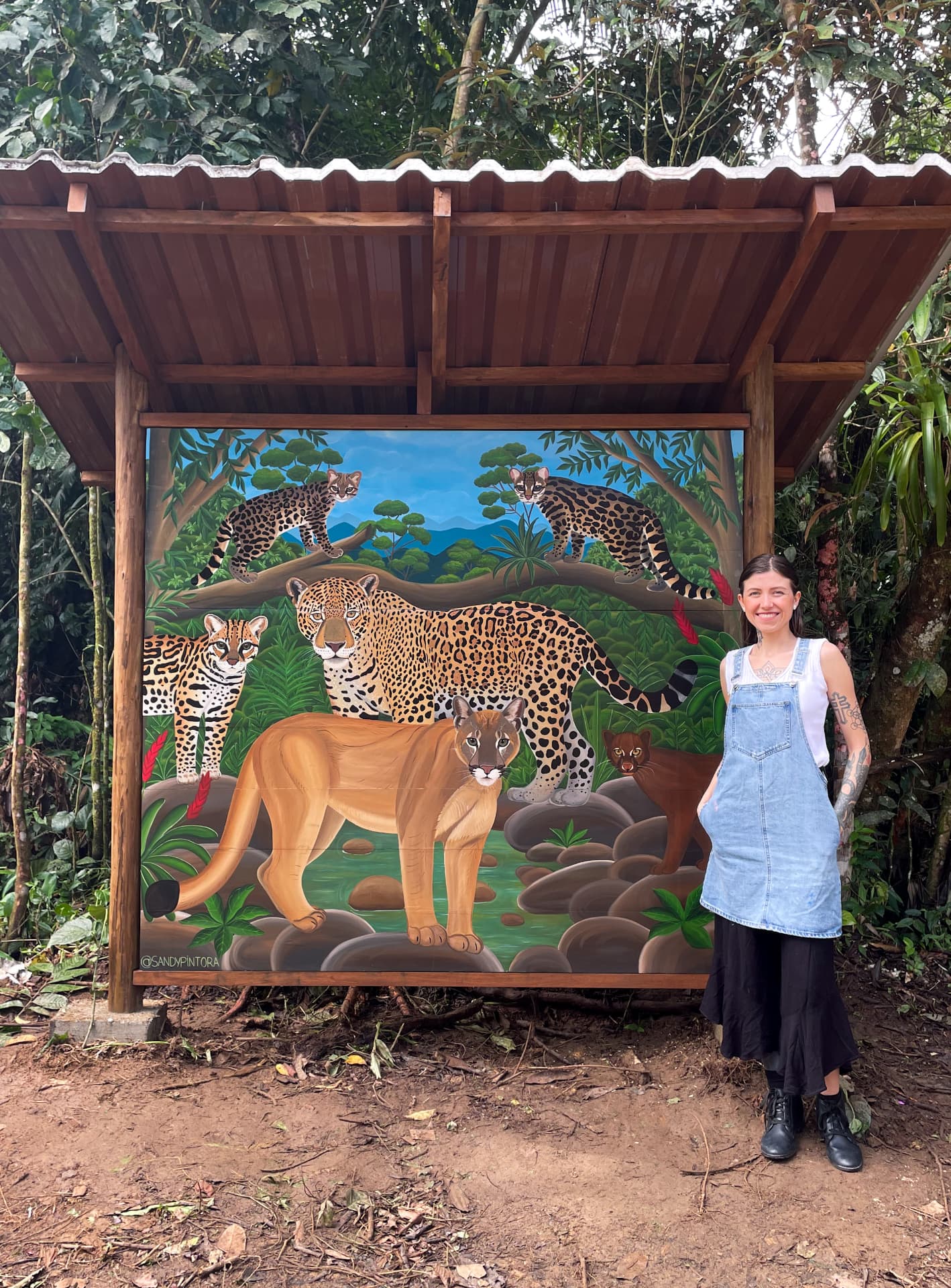 Sandy ao lado do painel inteiro Felinos da Mata Atlântica
