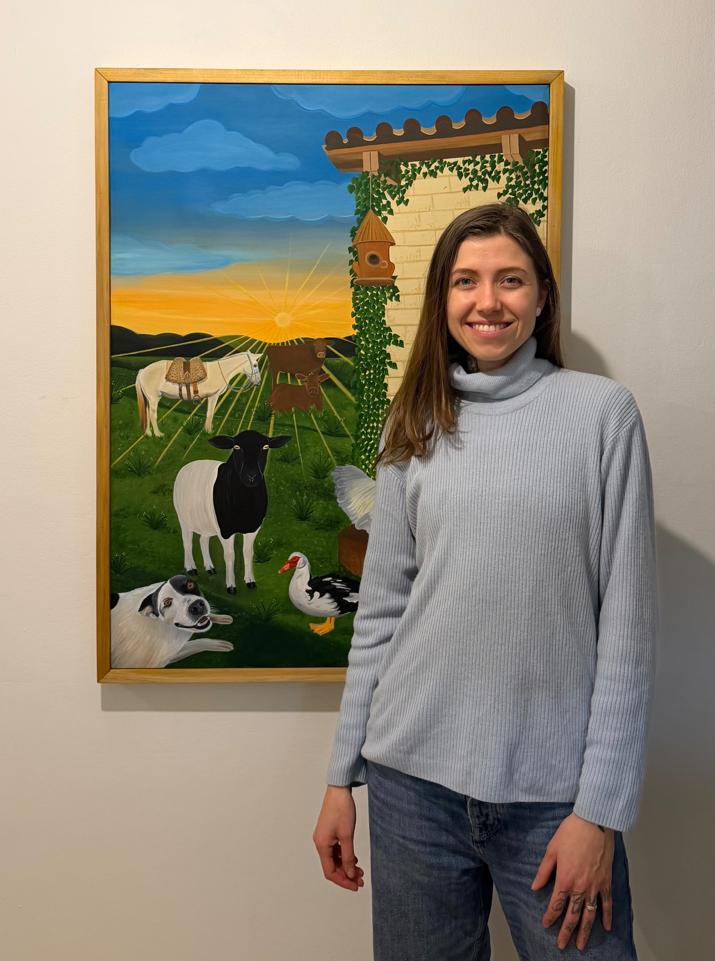 Sandy junto a uma pintura instalada em um ambiente